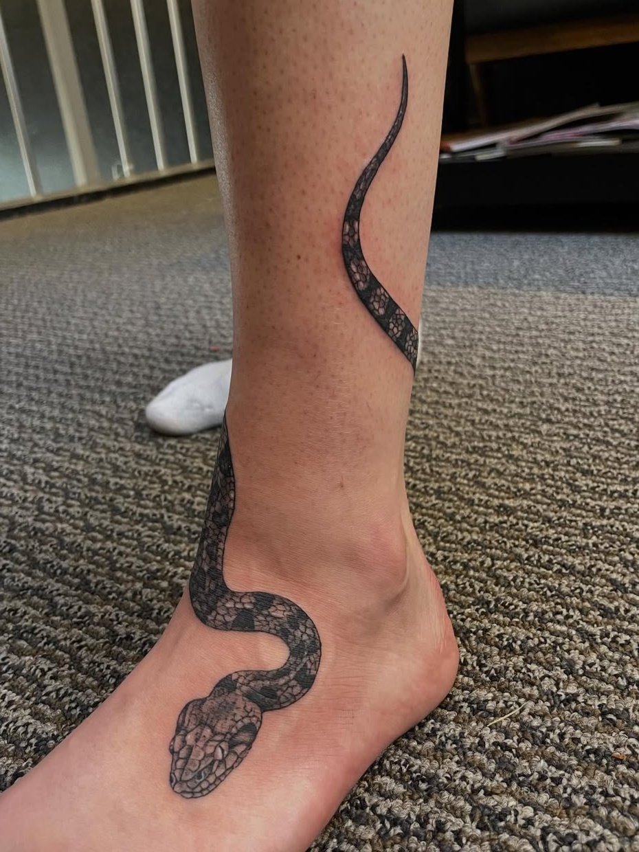 Coiled snake on lower leg and foot